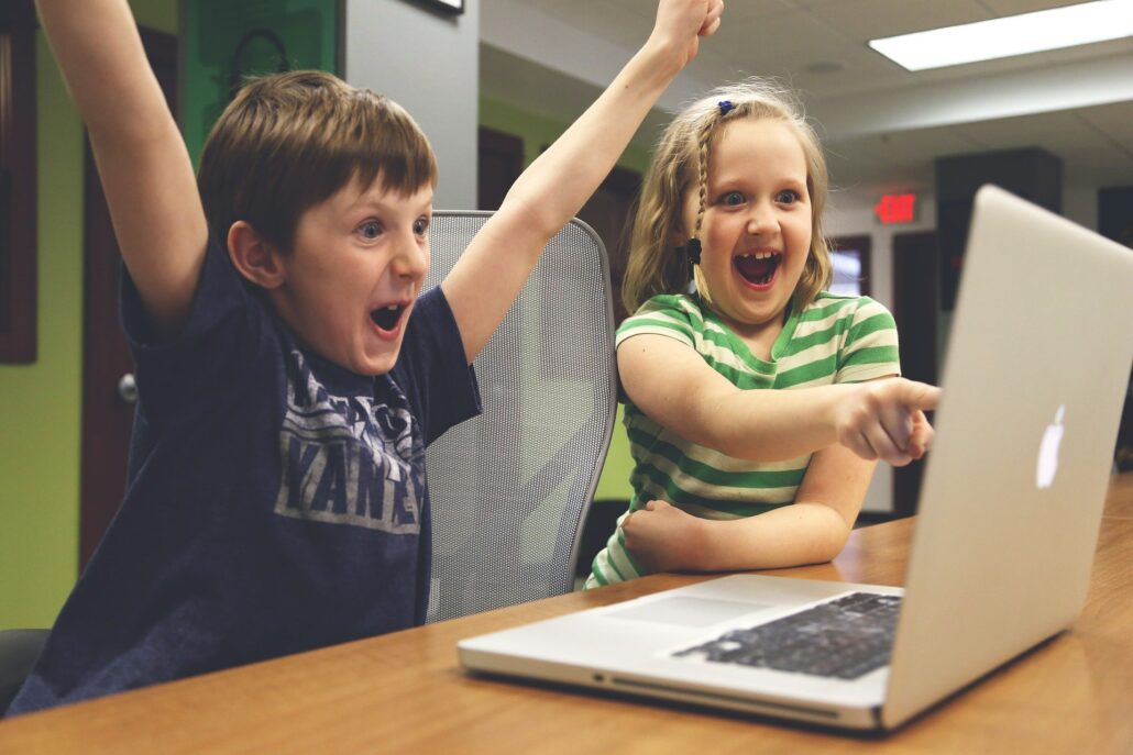 Two children playing at a computer